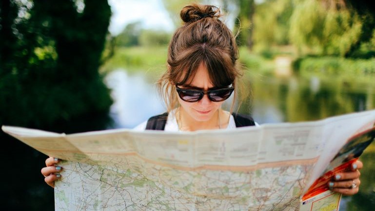 A woman reading a map while thinking about moving from Nevada to New Jersey