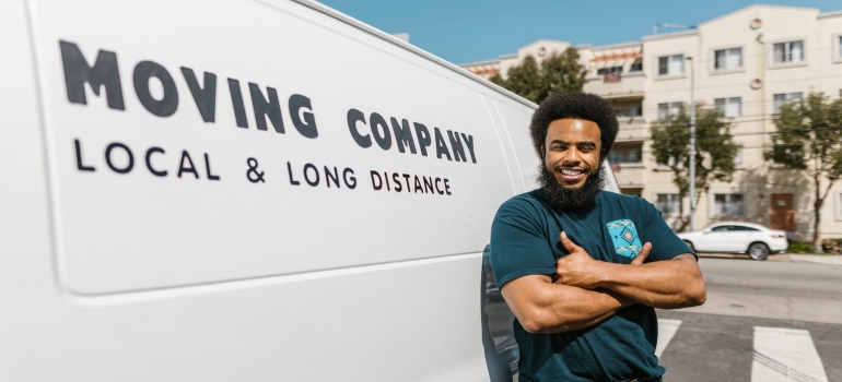 A mover in front of the white van as a representative of cross country moving companies California has 
