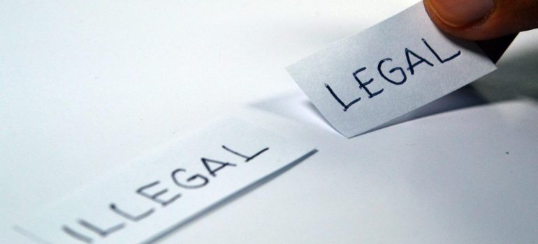 Two pieces of paper with the words legal and illegal written on them.