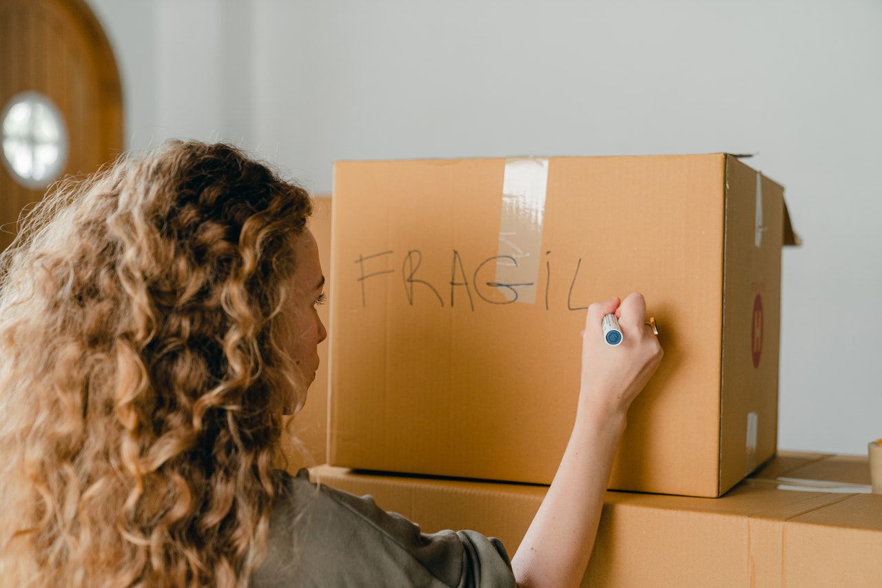 A girl labeling moving box fragile