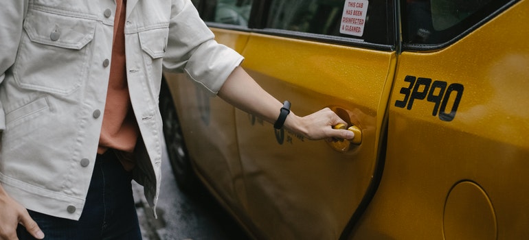 person holding the door on a cab