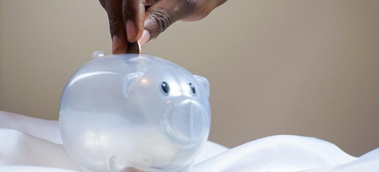 A person puttign a coin inside a piggy bank