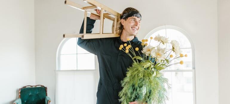 A mover handling a stool and plants