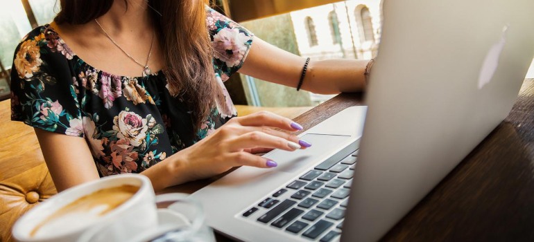 A woman using a laptop to find the top movers in El Paso.