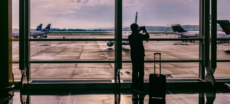 A man at the airport taking photos of planes.