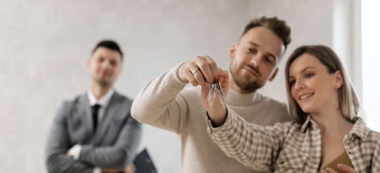 A couple holding the keys to a new house.