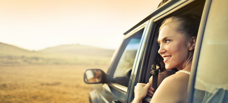 a woman looking through the car window and smiling