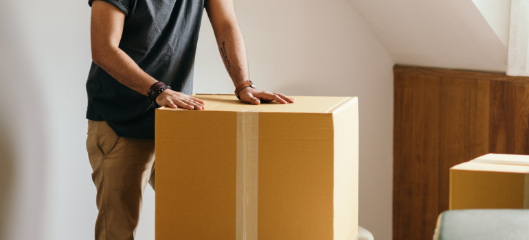A man holding both hands on a moving box