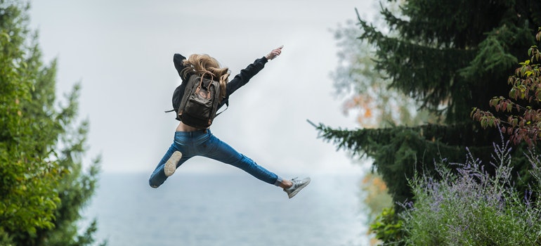 Young woman jumping with a backpack-