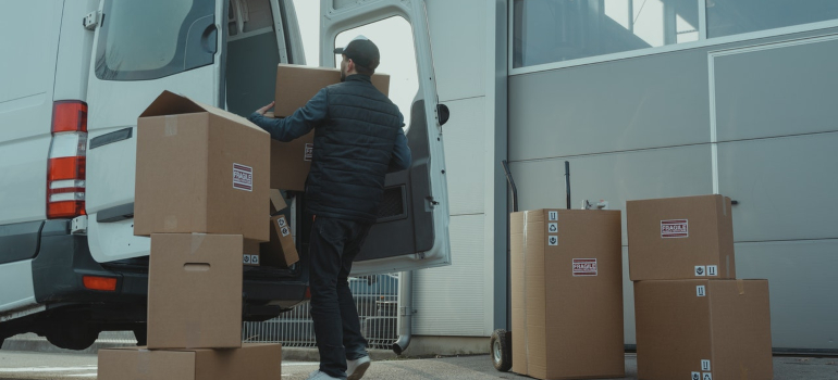 A man loading moving boxes to a van