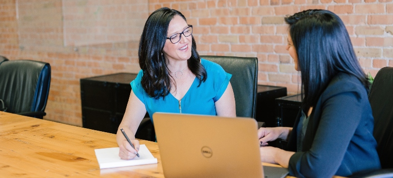 Two women talking in an office.