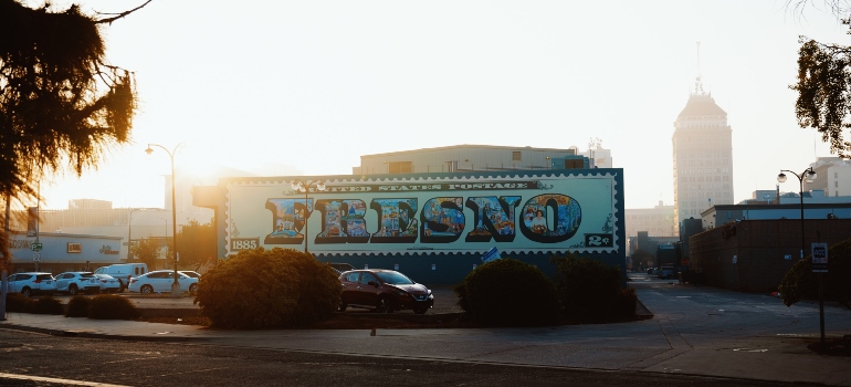 A graffiti that says Fresno with sunrise behind it.