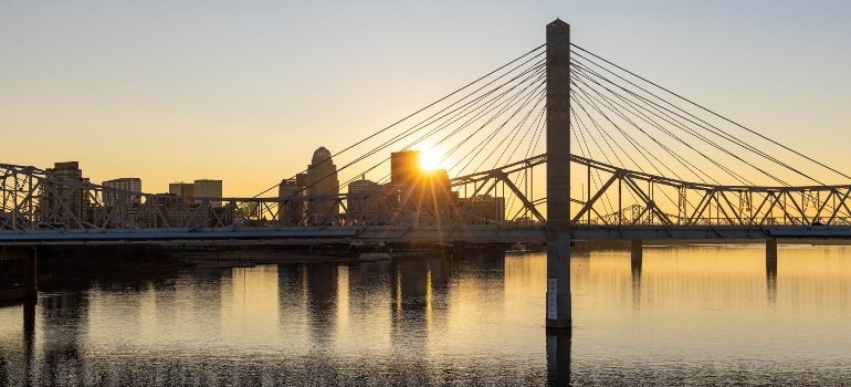 A bridge in Louisville with sun setting behind it.