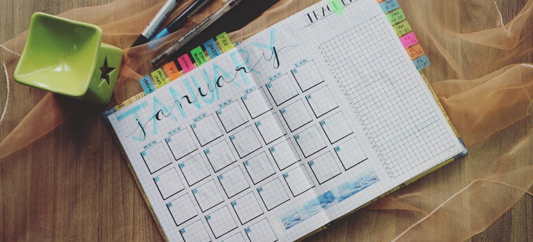 A calendar on a table with crayons next to it.