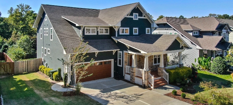 A house with grey roof and the garden around it.