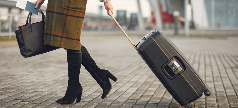 A woman walking with a suitcase.