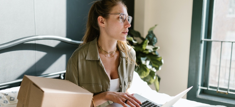 a woman looking for the best long distance moving companies Renton has to offer on her laptop