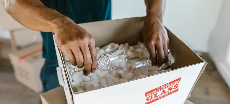 A mover packing glassware inside a box