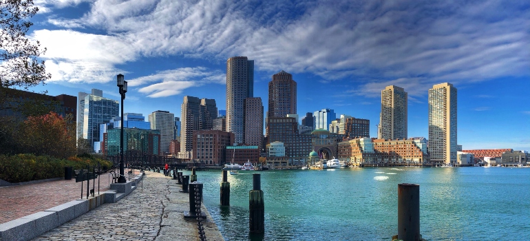 A skyline of Boston photographed near the water during a sunny day.