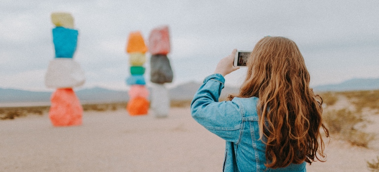 A woman photographing Seven Magic Mountains after moving from Seattle to Las Vegas.