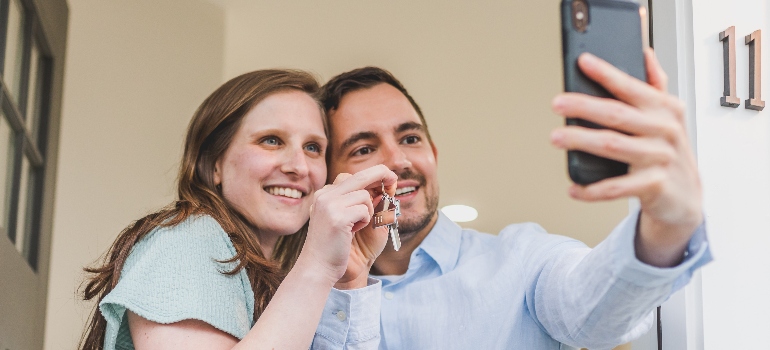 a couple taking a selfie while holding a key