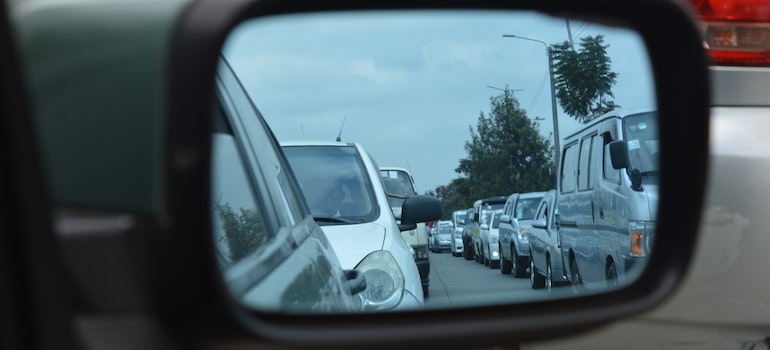A line of cars photographed in a rear view mirror.