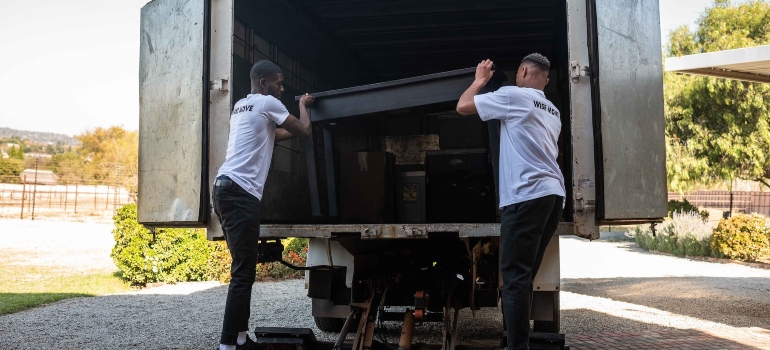 A photo of movers carrying items into a van
