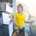girl pouring gas and thinking how gas prices impact moving costs