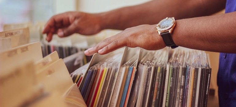 person going through records in order to pack vinyl records for moving