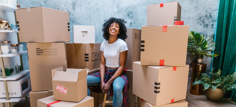 Woman sitting between moving boxes