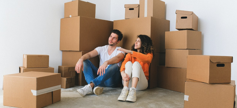 Man and woman sitting next to moving boxes