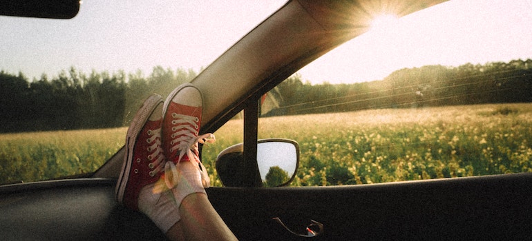 A person holding their feet up in the car and enjoying the trip.