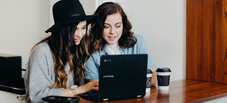 Two persons looking at a laptop, doing a research before moving from Arizona to Georgia