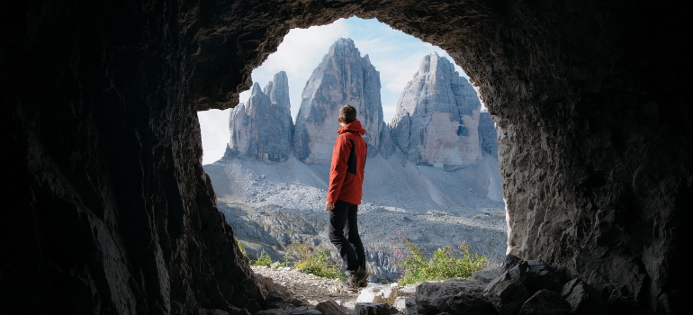 man standing in front of the cave enterance