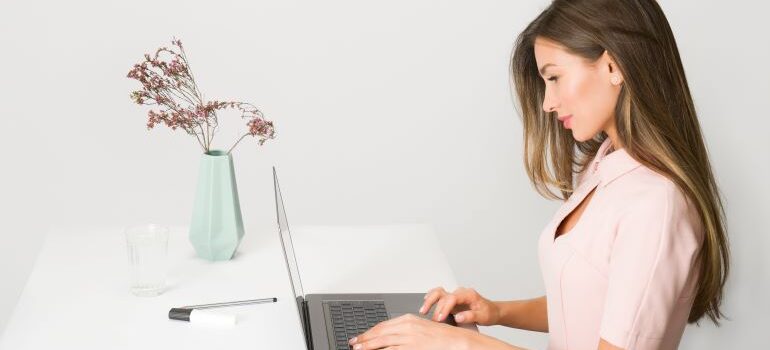 woman moving from North Carolina to California for work typing on the laptop.