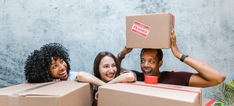 three people who are moving from michigan to illinois with boxes