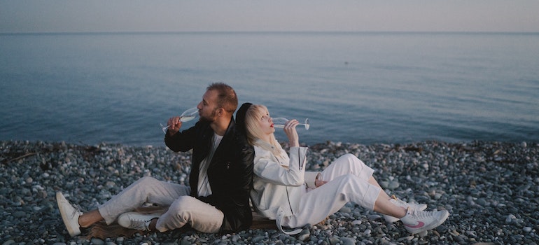 A couple drinking wine on a beach.