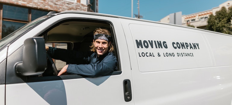 A man working for long distance moving companies Harrisonburg sitting in a van.