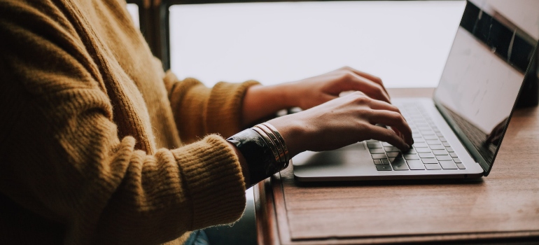 A person looking at a laptop, planning for moving from Boston to San Antonio