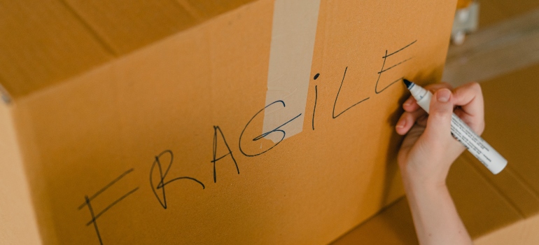 a person labeling a box as fragile