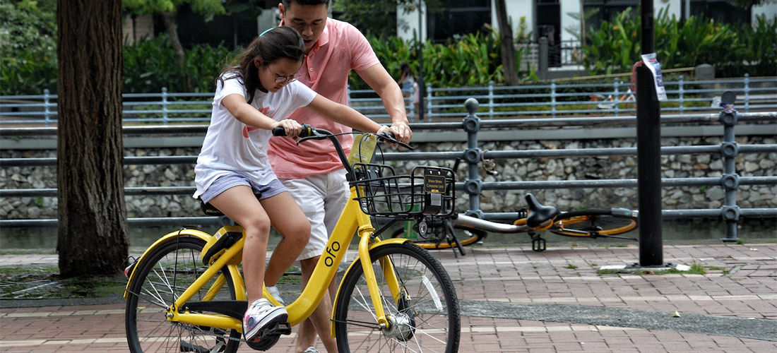A father teaching his daughter how to ride a bike