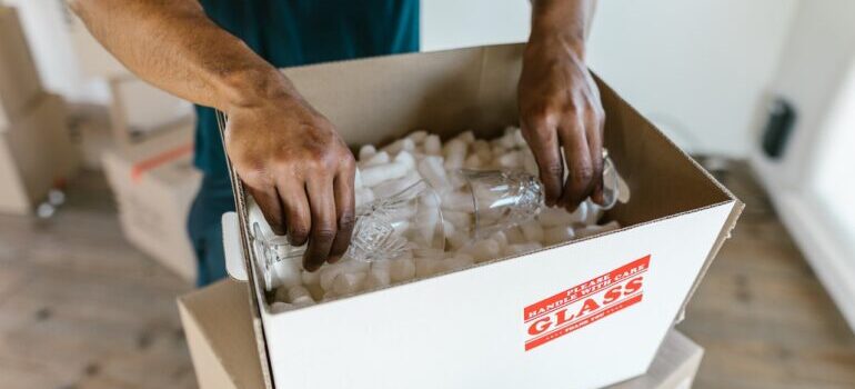 A man packing glasses to a box