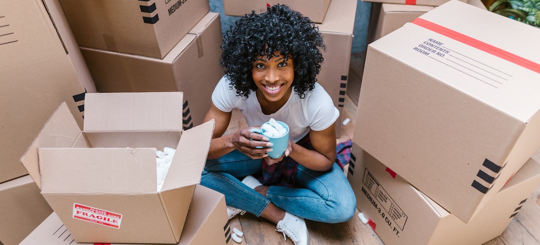 A woman smiling between carton boxes