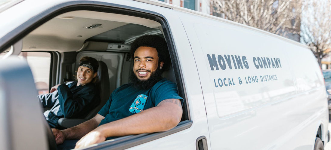 two men working for long distance moving companies Alabama sitting in a van.