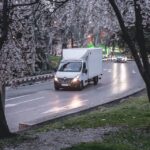 A white moving van driving on the road