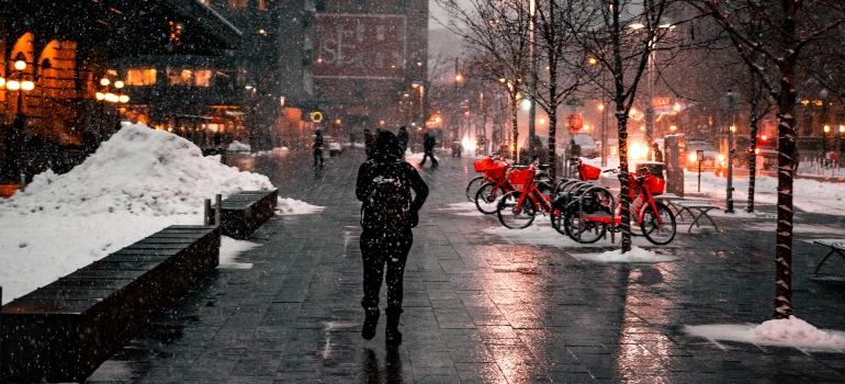 A man walking while the snow is falling