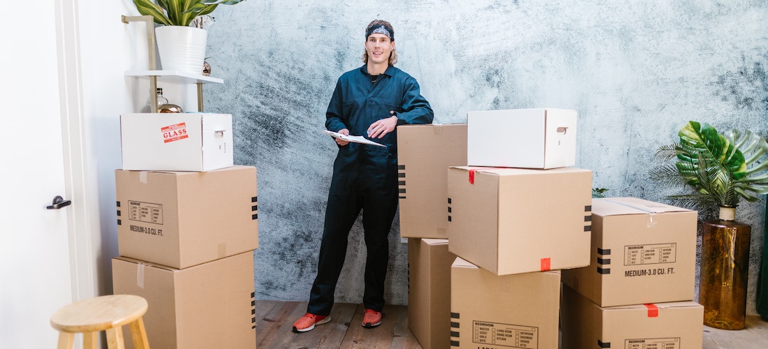 A man from cross country moving companies South Dakota standing between moving boxes