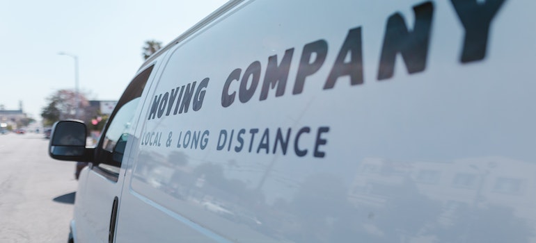 A white moving company van in the street