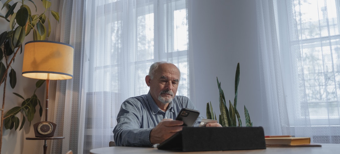 An elderly man looking at his phone