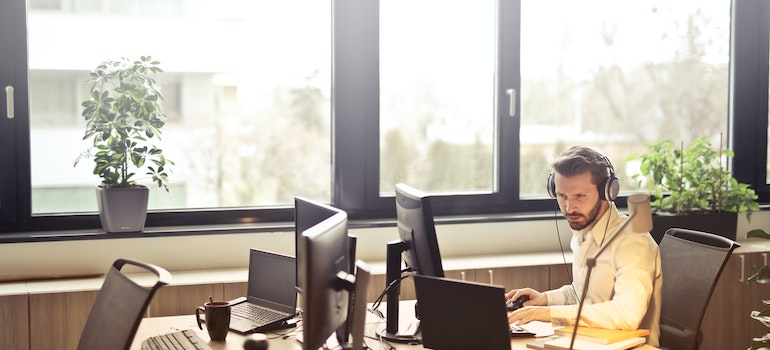 A person surrounded by laptops in an office after moving from South Carolina to Iowa